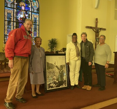Five people are standing on an altar by a portrait of Martin Luther King