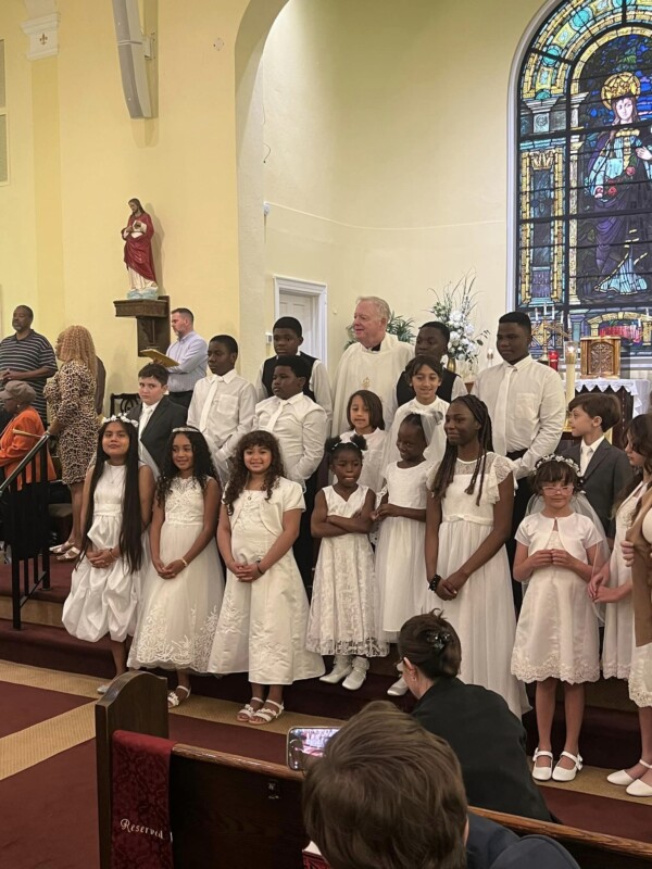children receiving first communion stand on the altar at saint elizabeth's church